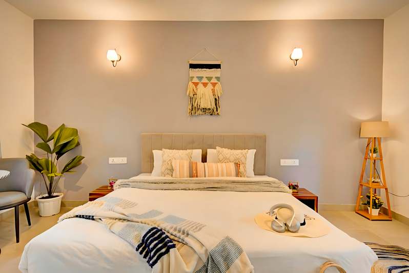 Smiling blogger at a well-styled bedside setup with two matching nightstands